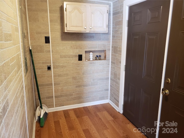 laundry area with washer hookup, cabinets, and light wood-type flooring