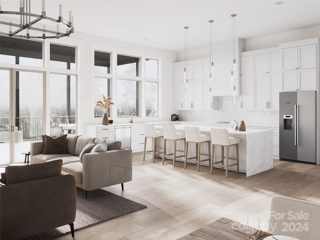 interior space featuring decorative light fixtures, stainless steel refrigerator with ice dispenser, a kitchen island, and a kitchen breakfast bar