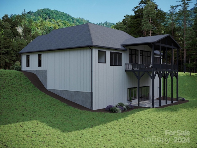 view of property exterior with a balcony and a lawn