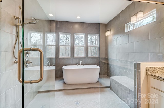 bathroom with vanity, tile walls, plus walk in shower, and tile patterned floors