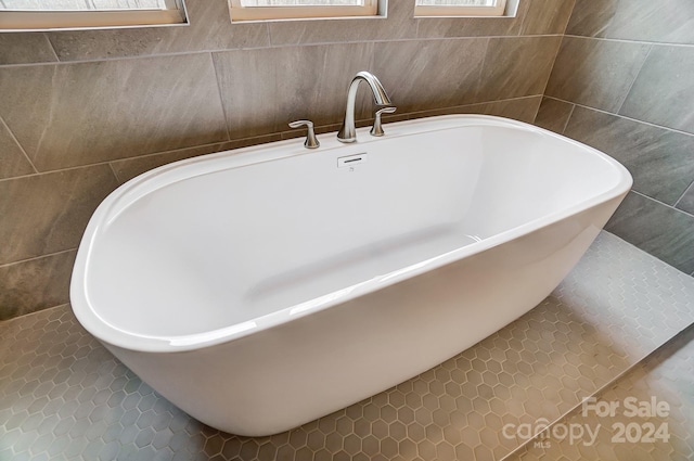 bathroom featuring tile walls, a bath, and tile patterned floors