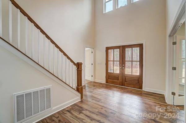 foyer with a high ceiling, french doors, and hardwood / wood-style flooring