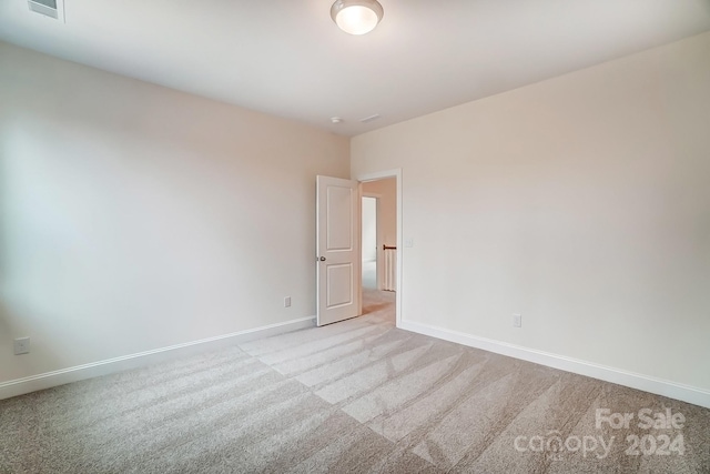 unfurnished room featuring light colored carpet