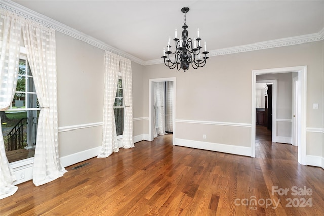 unfurnished dining area with a notable chandelier, crown molding, and dark hardwood / wood-style flooring