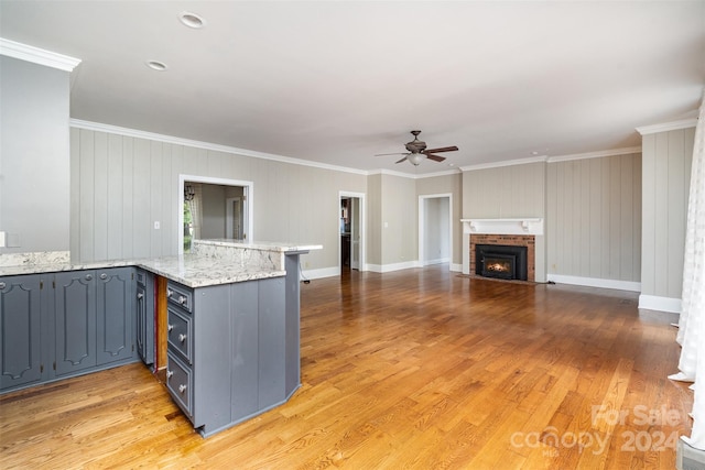 kitchen featuring light hardwood / wood-style flooring, kitchen peninsula, and crown molding