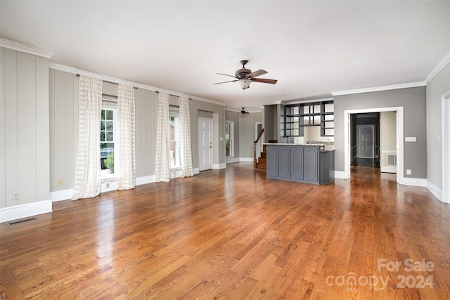 unfurnished living room featuring crown molding, ceiling fan, and hardwood / wood-style flooring