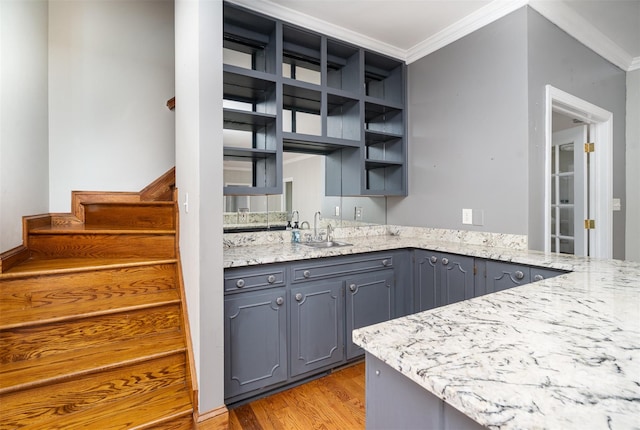 kitchen with gray cabinets, light hardwood / wood-style floors, sink, and crown molding