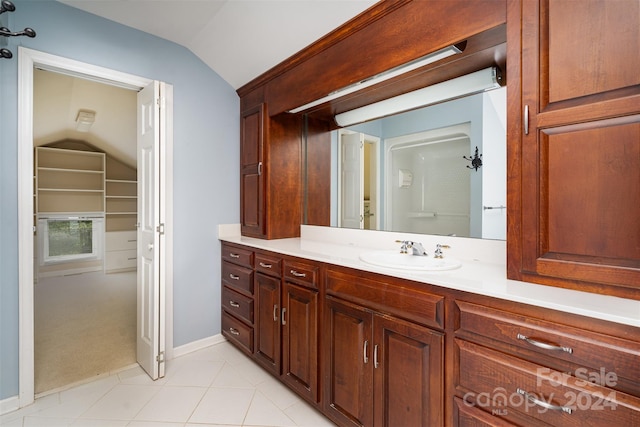 bathroom with vanity, tile patterned flooring, and vaulted ceiling