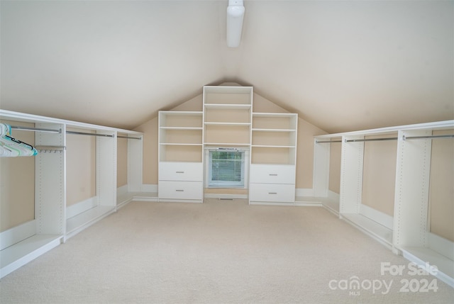 walk in closet featuring light colored carpet and lofted ceiling