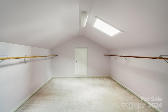 spacious closet featuring vaulted ceiling and light carpet