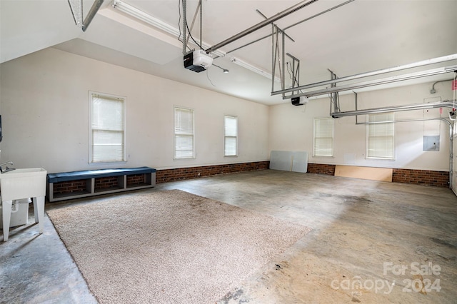 garage with a garage door opener and electric panel