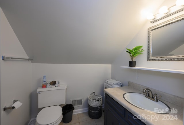 bathroom featuring tile patterned flooring, vanity, toilet, and vaulted ceiling