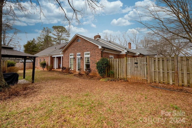 view of home's exterior with a gazebo and a yard