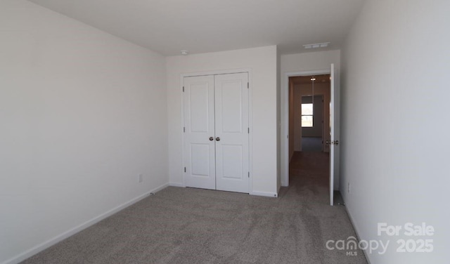 unfurnished bedroom with carpet floors and a closet