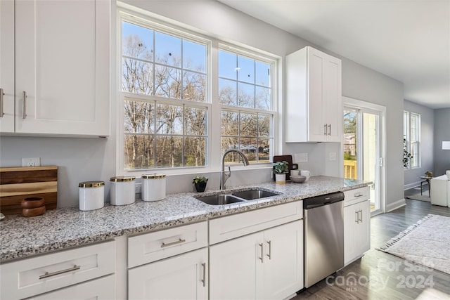 kitchen with dishwasher, sink, a healthy amount of sunlight, light stone counters, and white cabinets