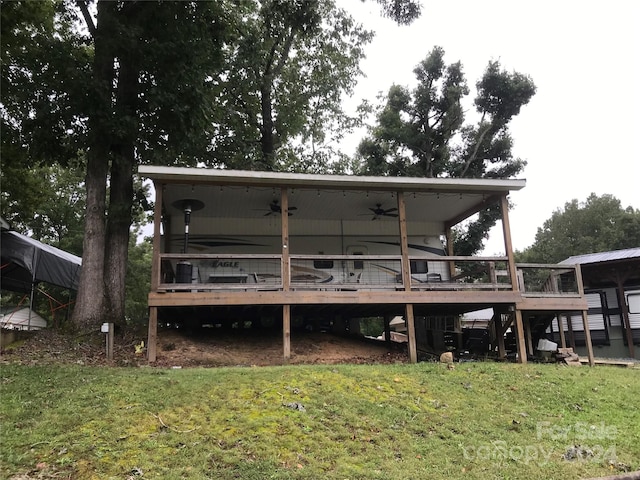 rear view of property with a lawn, ceiling fan, and a deck