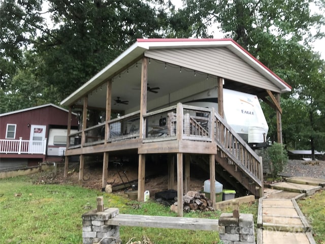 rear view of property with a lawn, ceiling fan, and a wooden deck