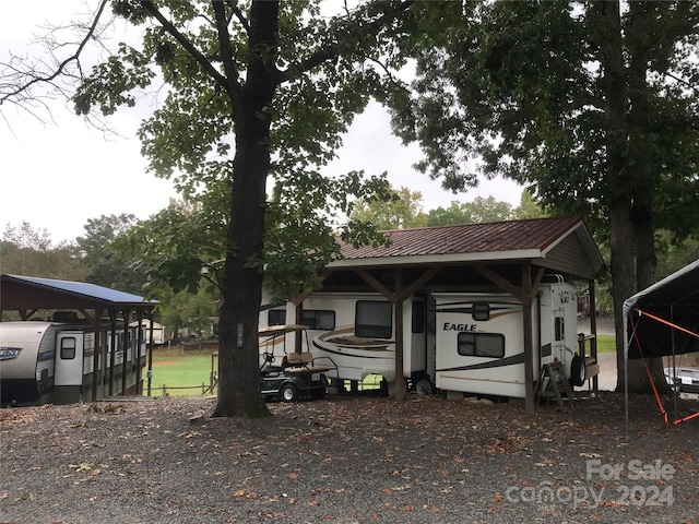 back of house featuring a carport