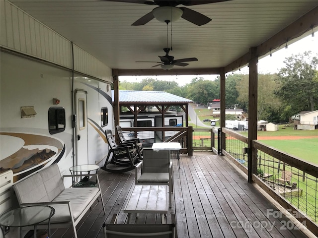 wooden deck featuring a yard and ceiling fan