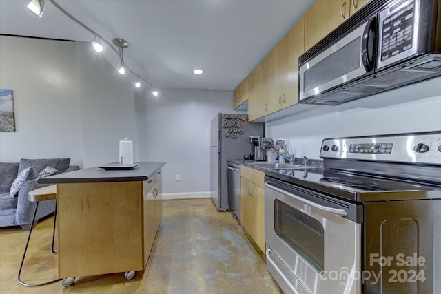 kitchen featuring appliances with stainless steel finishes, sink, a kitchen island, and a breakfast bar area