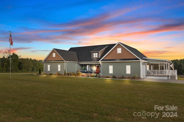 view of front of house with covered porch and a yard