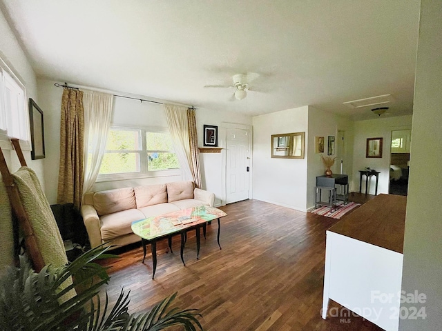 living room featuring dark wood-type flooring and ceiling fan