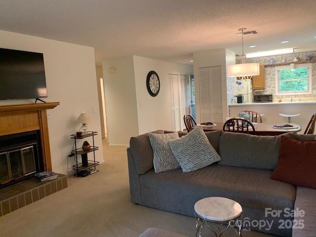 carpeted living room featuring a brick fireplace