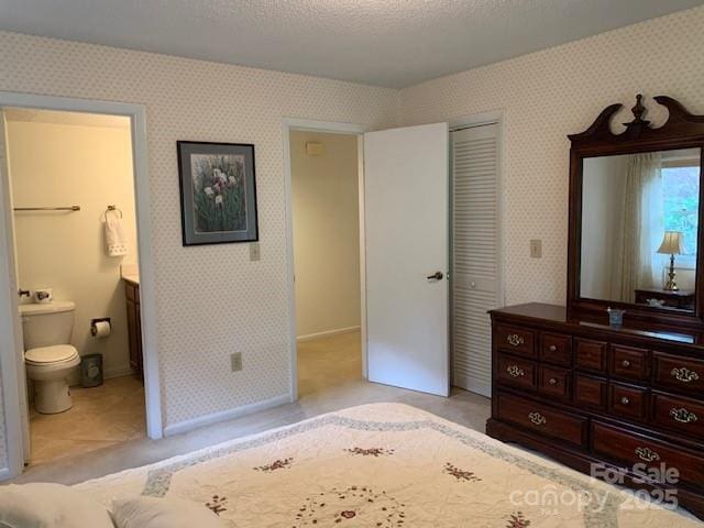 bedroom featuring a textured ceiling, a closet, and connected bathroom