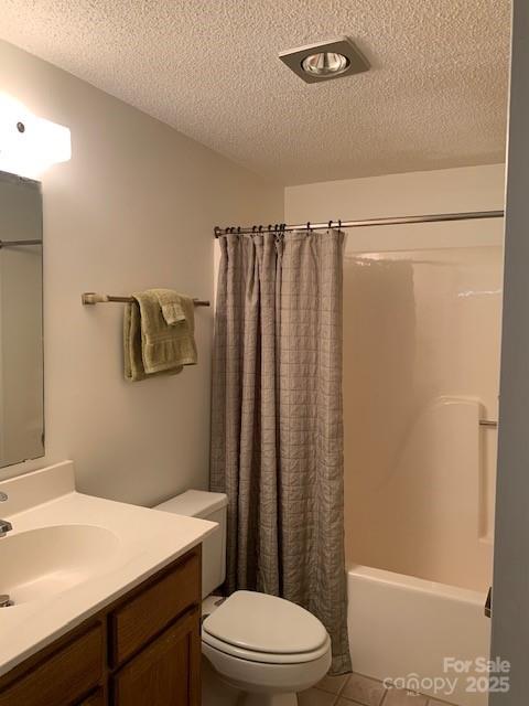 full bathroom featuring a textured ceiling, shower / bathtub combination with curtain, tile patterned flooring, vanity, and toilet