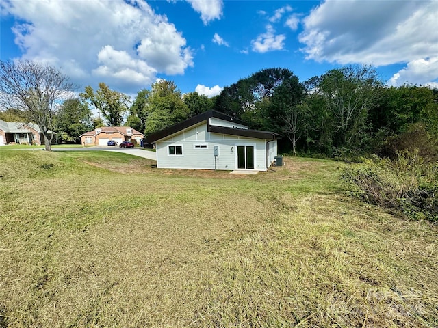 back of house featuring a lawn and cooling unit