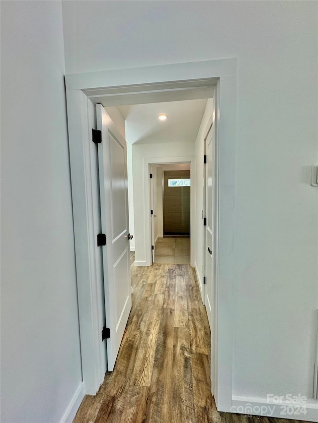 hallway with baseboards and wood finished floors