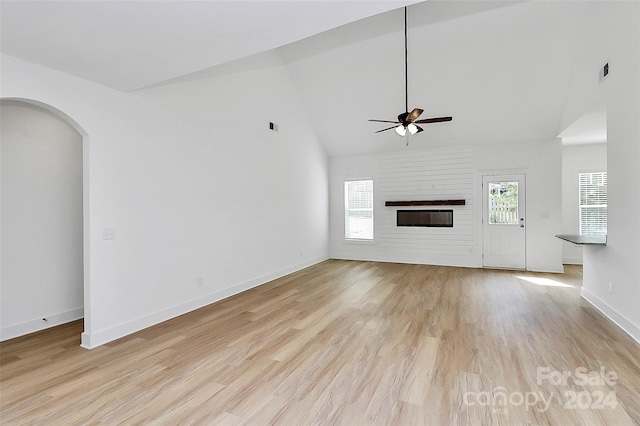 unfurnished living room featuring ceiling fan, high vaulted ceiling, and light wood-type flooring