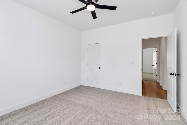 unfurnished bedroom with ceiling fan, a closet, and light colored carpet