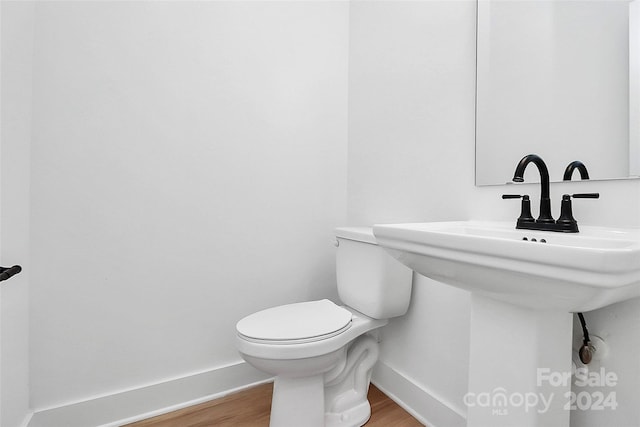 bathroom with hardwood / wood-style floors and toilet