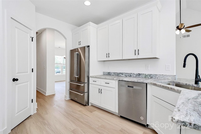 kitchen with light hardwood / wood-style flooring, white cabinets, and appliances with stainless steel finishes