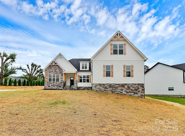 craftsman-style house with board and batten siding and a front yard