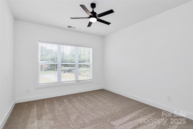 unfurnished room with visible vents, carpet flooring, a ceiling fan, and baseboards