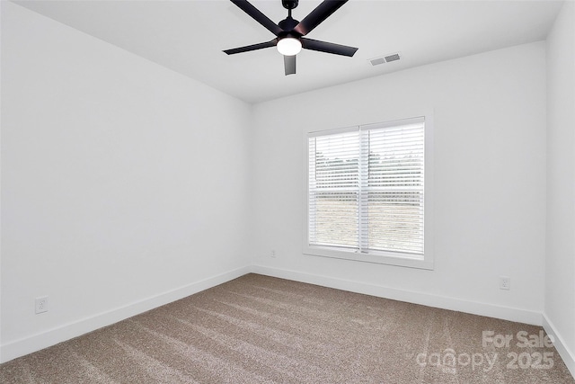 spare room with carpet, visible vents, ceiling fan, and baseboards