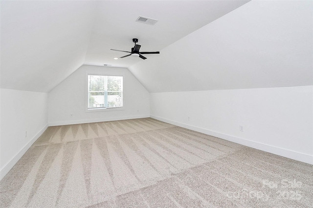 bonus room featuring light colored carpet, visible vents, lofted ceiling, and baseboards