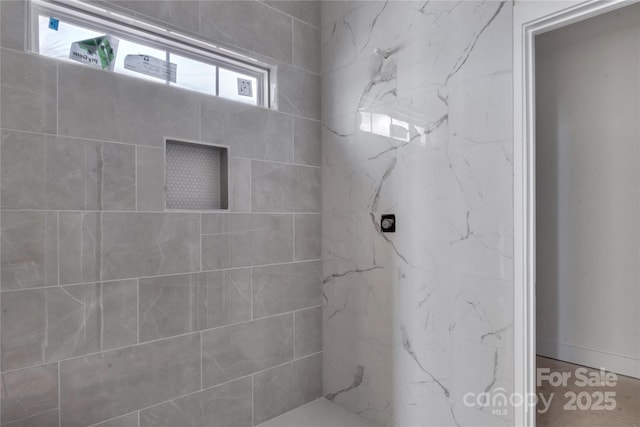 bathroom featuring a marble finish shower