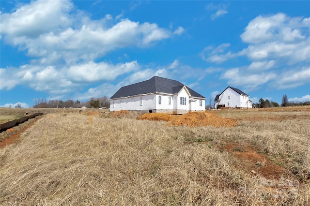 view of side of home with a rural view and crawl space