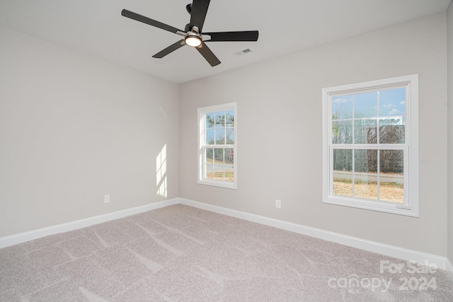 empty room featuring ceiling fan and carpet