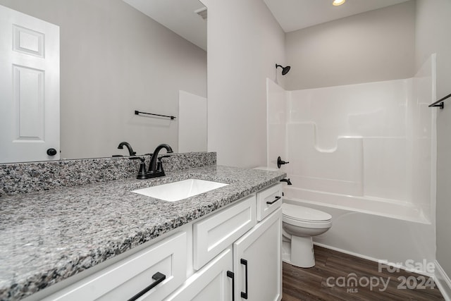 full bathroom with washtub / shower combination, hardwood / wood-style floors, vanity, and toilet