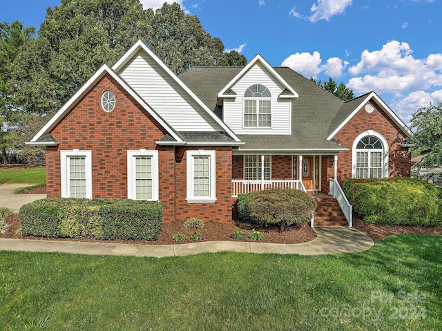 2488 Birdie Ln NE, Conover, NC 28613 - traditional-style house featuring a front lawn, a porch, brick siding, and roof with shingles