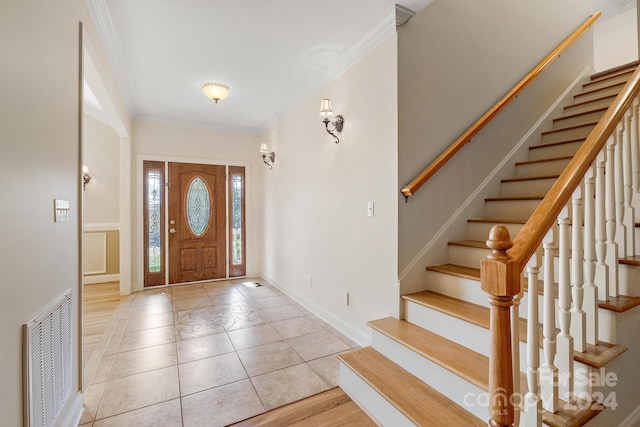 foyer entrance featuring crown molding and light hardwood / wood-style floors