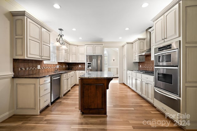 kitchen featuring cream cabinetry, pendant lighting, stainless steel appliances, and tasteful backsplash