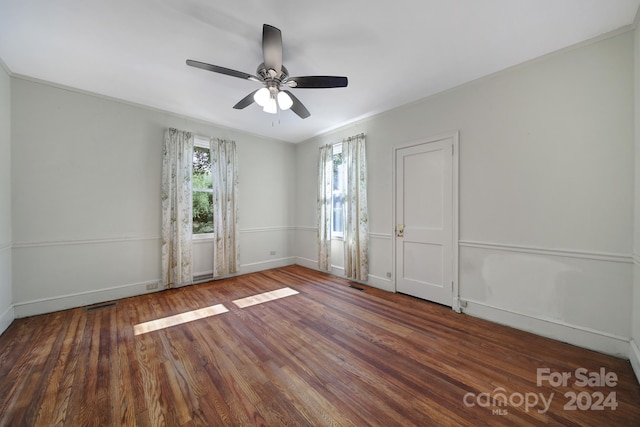 spare room with ceiling fan, crown molding, and dark wood-type flooring