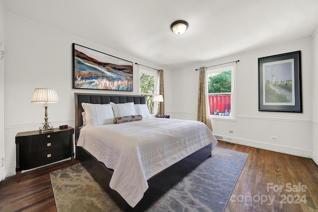 bedroom featuring ornamental molding and dark wood-type flooring