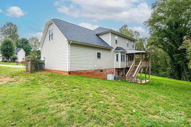 rear view of house with a yard, central AC, and a wooden deck