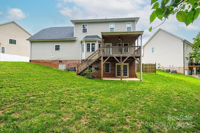 rear view of house featuring ceiling fan, a yard, a wooden deck, cooling unit, and a patio area